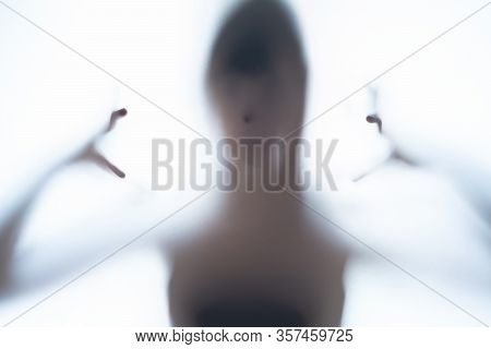 Blurred Silhouette Shadow Of A Terrorific Body Shape Behind A White Background Showing Head And Cree