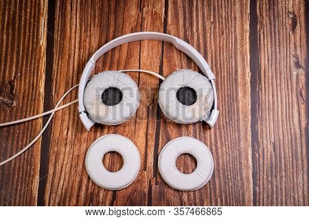 Need A Replacement Embouchures On Old White Earbud. Repair Accessories.wooden Background