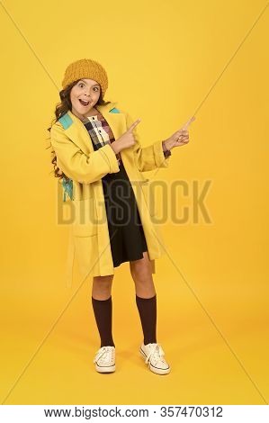 Look At Closely. Surprised Child In Autumn Fashion Pointing At Something. Small Schoolgirl With Open