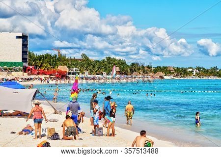 Playa Del Carmen, Mexico - Dec. 26, 2019: Crowded Beach Filled With People Playing And Sunbathing At