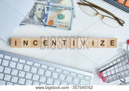 Modern Business Buzzword - Incentivize. Top View On Keyboard And Dollar With Wooden Blocks. Top View