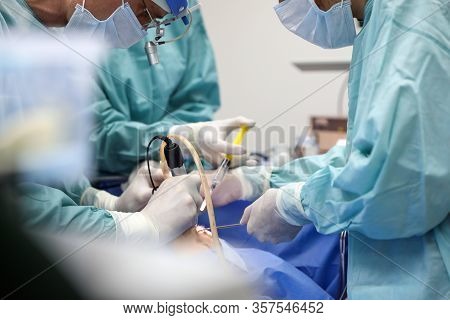 Team Of Professional Doctors Performing Operation In Surgery Room