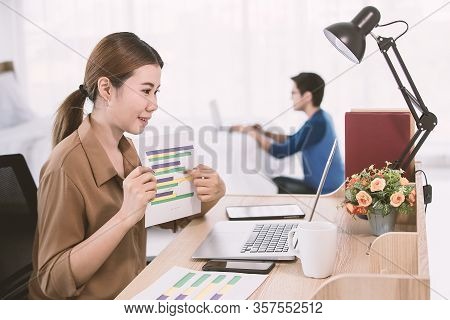 Asian Businesswoman Showing The Business Graph To Notebook Computer During The Office Online Meeting