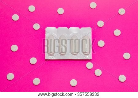 Plastic Packaging With Vaginal Or Rectal Suppositories Is On Pink Background Surrounded By Round Tab