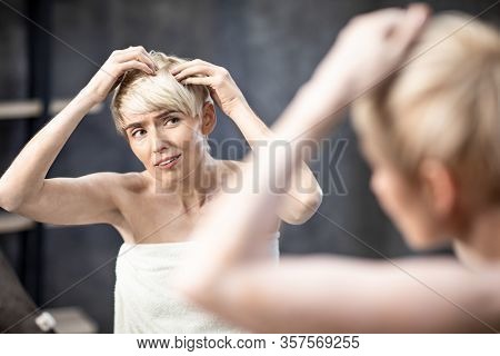 Lady Suffering From Dandruff Problem Touching Hair With Flakes Standing In Bathroom At Home. Selecti