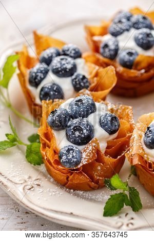 Phyllo Cups With Mascarpone Cheese Filling Topped With Fresh Blueberries Sprinkled With Powder Sugar