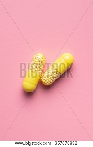 Vitamin capsules. Vitamin C pills on pink background. Top view.