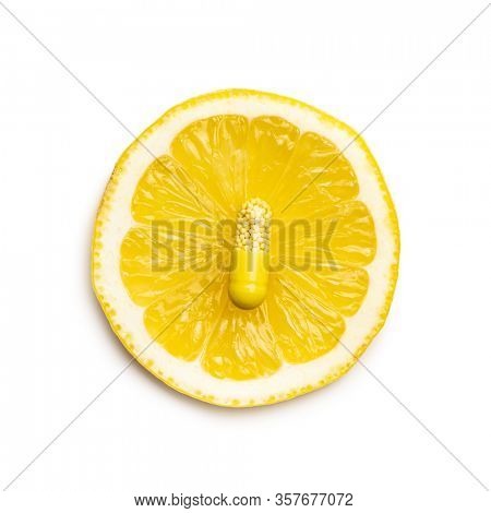 Vitamin capsules. Vitamin C pills and slice of lemon isolated on white background. Top view.