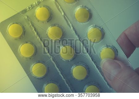 Blister With Yellow Vitamins Or Pills In Female Fingers.
