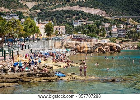 Loutra Edipsou, Evia, Greece- June,11 2018. Enjoying tourists in the warm medicinal spa water that springs from the rocks on the Aegean coast. Lutra Edipsou, Evia island, Greece