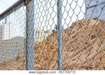 Pile Of Sand At Construction Site Behind Metal Fense