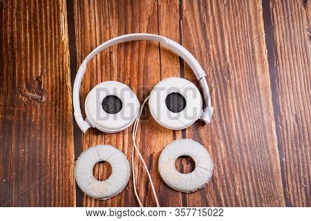 Need A Replacement Embouchures On Old White Earbud. Repair Accessories.wooden Background