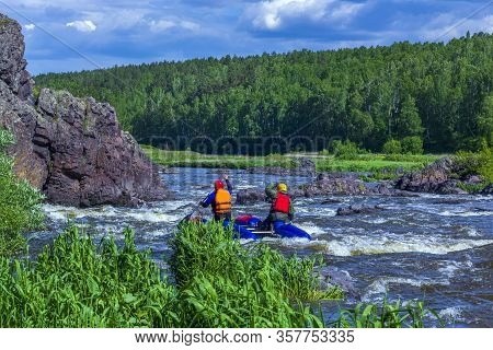 Extreme Whitewater Rafting Trip. A Group Of People (team) In Sport сatamarans Practise Traversing Th