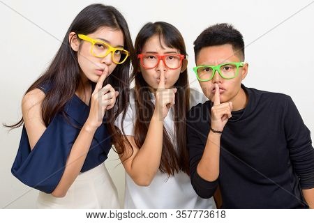 Three Young Asian Women As Friends With Finger On Lips Together