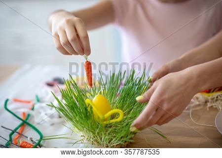 Close Up Picture Of Girls Hand Putting Carrot To The Easter Basket