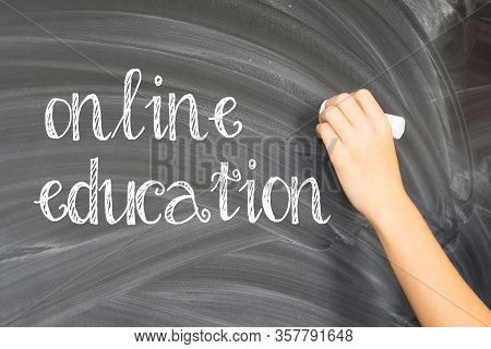 Hand With Chalk Writting On Empty Black Board Online Education