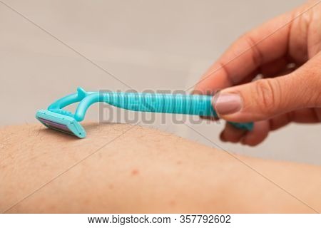 Close Up Picture Of Woman Holding Razor, Shaving Her Hairy Leg With Folliculitis