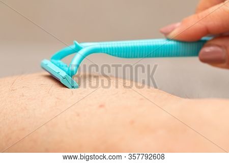Close Up Picture Of Woman Holding Razor, Shaving Her Hairy Leg With Folliculitis