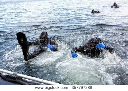 Teriberka, Russia - July 29, 2017: Two Scuba Divers Diving From A Boat Into The Water. Shot In Baren