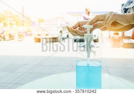 Woman Uses Her Hand To Press Hand Sanitizer Bottle To Clean Her Hand At Wayside In The City. Concept