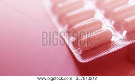One Blister Of Pills Closeup. Oval Long Shape Remedies. Red Tone, Sun Fleck. Background Or Texture A