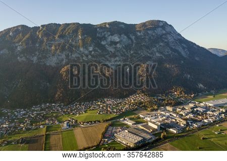 Aerial View Of Green Meadows With Villages And Forest In Austrian Alps Mountains.