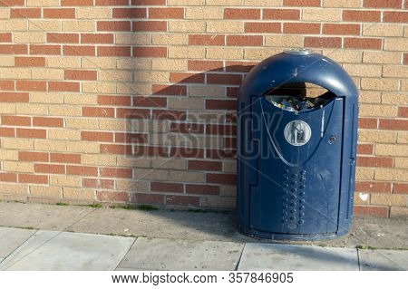 A Close Up View Of A Blue Public Dustbin Outisde A Supermarket