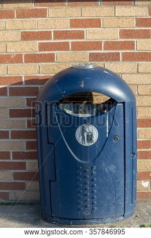 A Close Up View Of A Blue Public Dustbin Outisde A Supermarket