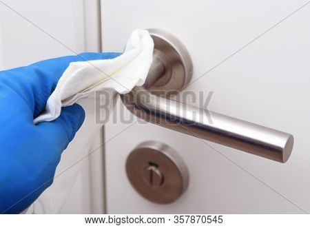 Disinfection In Public Places, The Fight Against The Virus, Coronavirus.worker's Hand Wipes The Door