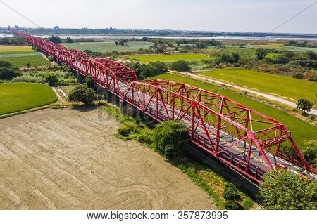 red famous Xilou Bridge over the river and farm in Yunlin county, Taiwan