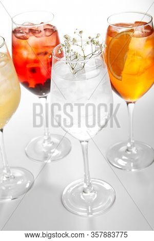 Spritz fruit cocktails. Alcohol soft drinks in glasses side view. Refreshment beverage with coconut, berry, orange in drinkware. Exotic summer beach cocktail portions with crushed ice in glassware