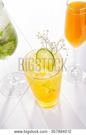 Passion fruit and cucumber cocktail close up. Alcohol drink in glass top view. Beverage with fruit juice, ice tea in drinkware. Summer beach exotic cocktail portion with crushed ice in glassware