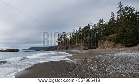 Distant Backpacker Hiking Along The Beach On The West Cost Trail On Vancouver Island, British Columb