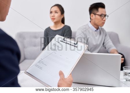 Young Angry Couple Of Cheated Investors Holding Papers Arguing With Male Real Estate Agent, Defraude