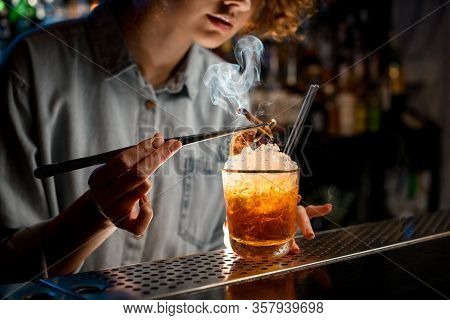 Young Woman At Bar Accurate Decorates Bright Cocktail Like Negroni Using Tweezers.