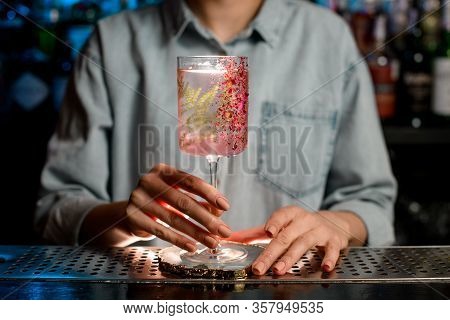 Womans Hand Holds Decorated Glass With Pink Drink.