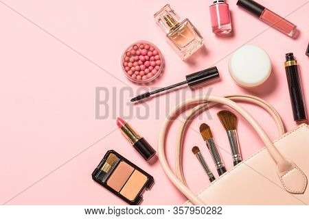 Cosmetics, Makeup Product On Pink Background. Cream, Lipstick, Powder, Mascara And Brushes With Bag.