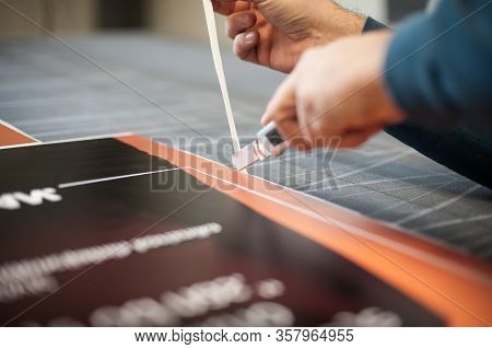 Close-up Of Hand With Skalpel. Worker Cut Paper In Printshop