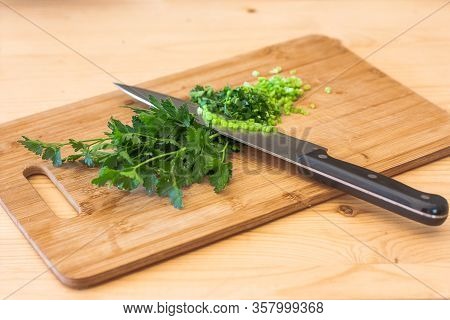 Fresh Parsley Cut On Wooden Cutting Board With Chefs Knife