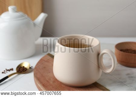 Cup Of Aromatic Buckwheat Tea And Granules On White Table