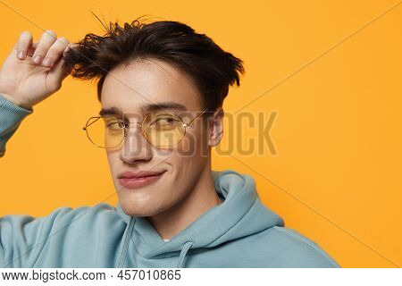 A Close Portrait Of A Funny Man Standing On An Orange Background In Bright Sunglasses Looking At The