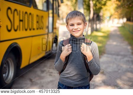 Cheerful Young Boy With A Backpack Returning Home By School Bus. Elementary School Learner Happy To 