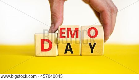Demo Day Symbol. Concept Words Demo Day On Wooden Cubes. Businessman Hand. Beautiful Yellow Table Wh