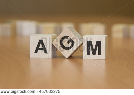 Word Agm Written On Wooden Cubes. Tax Concept. Wooden Background. Agm - Short For Annual General Mee
