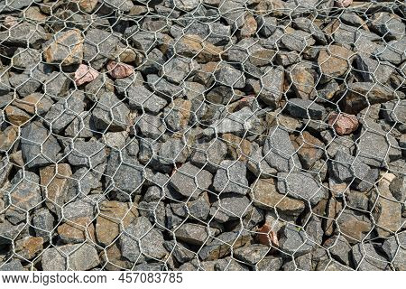 Granite Gravel Reinforcement Of Road Embankment Covered Wth Steel Mesh At Direct Sunlight - Full-fra