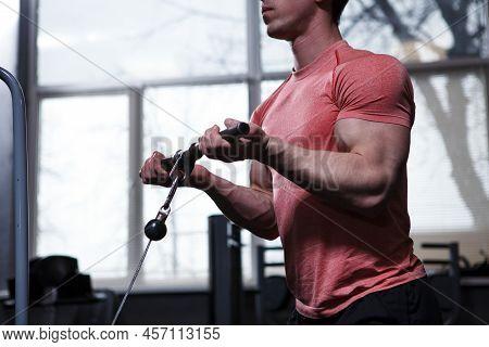 Cropped Shot Of A Muscular Bodybuilder Doing Bicep Curls In Cable Crossover Gym Machine