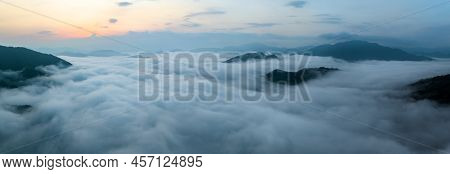 Panorama Of Sea Of Clouds Around Mountain Peaks At Sunrise