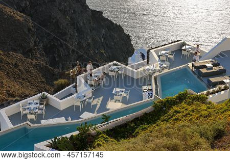 Imerovigli, Santorini, Greece - June 29, 2021: Tables On The Restaurant Terrace With A Picturesque V