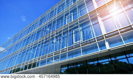Modern Office Building With Glass Facade On A Clear Sky Background. Transparent Glass Wall Of Office