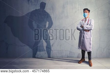 Brave Doctors With His Shadow Of Superhero On The Wall. Concept Of Powerful Man